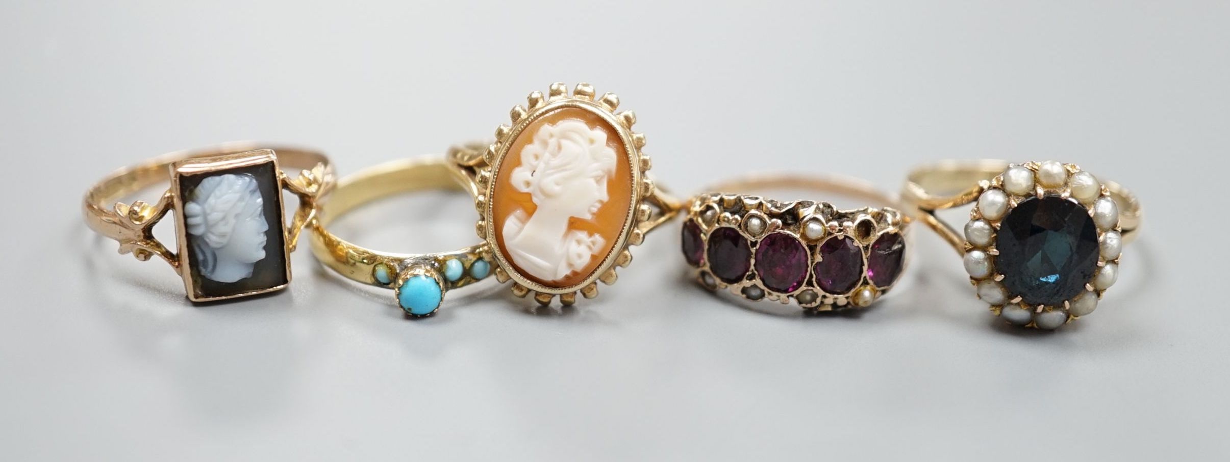 A Victorian yellow metal, garnet and seed pearl half hoop ring(a.f.) and a yellow metal and turquoise set ring, gross 3 grams and three later 9ct gold and gem set rings including two cameo, gross 8.5 grams.